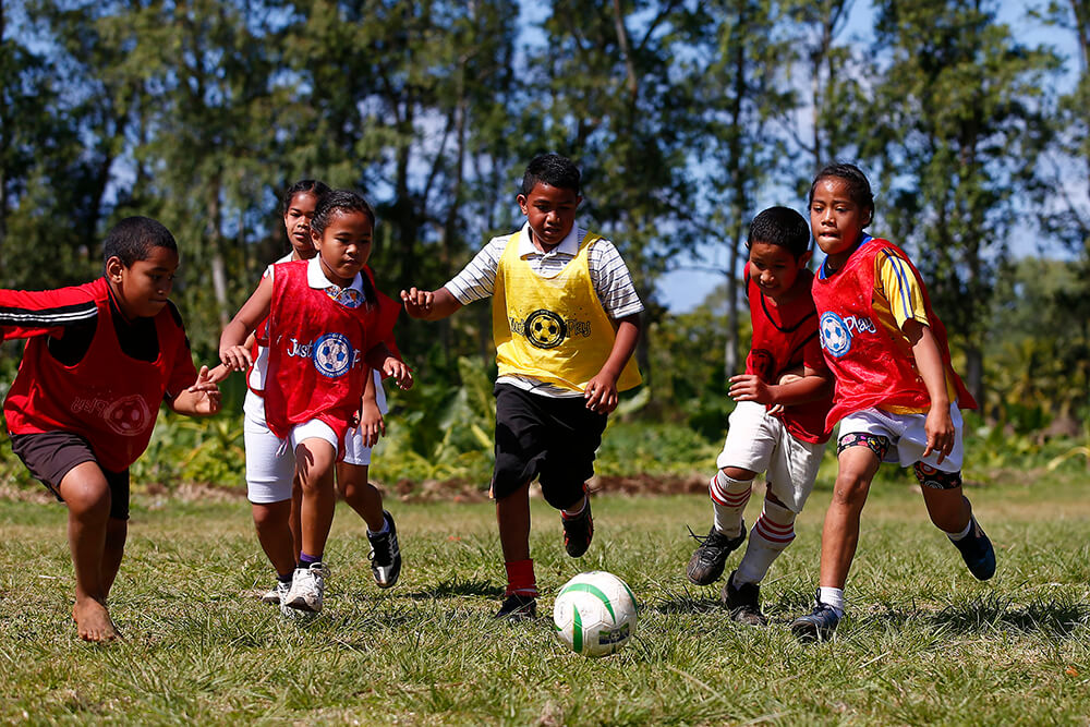 Young children play football in Tonga