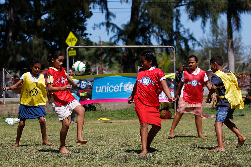 Young children play football in Tonga