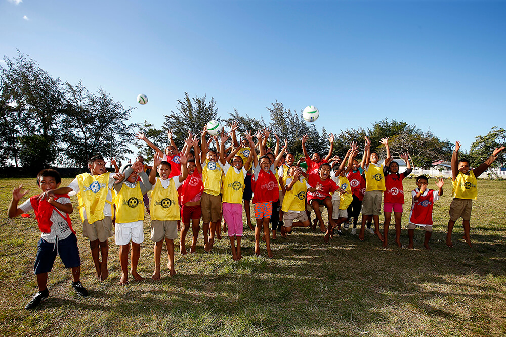 Young children play football in Tonga