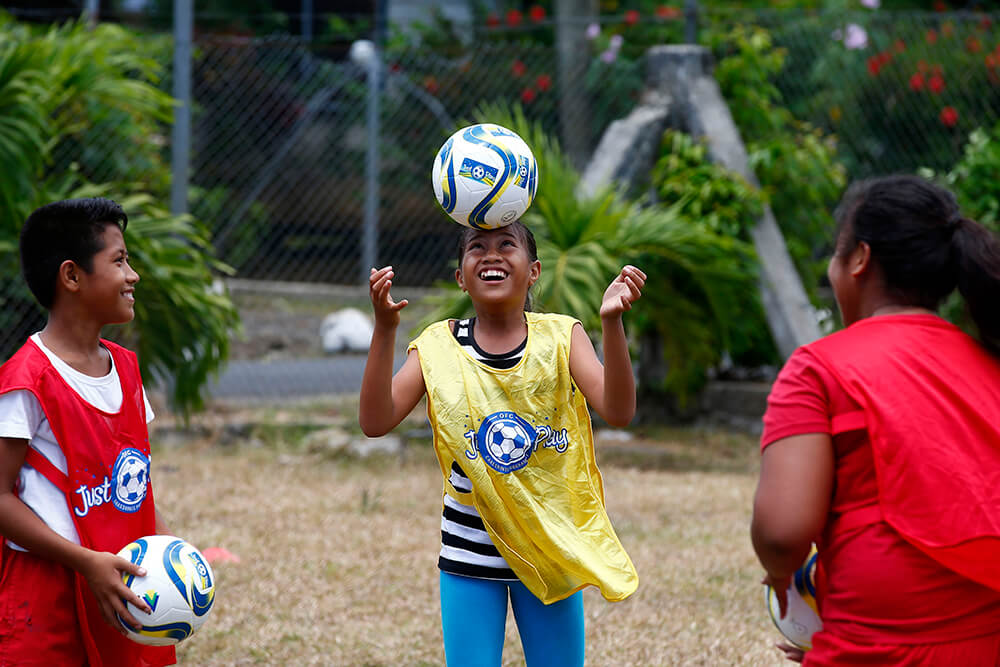Happy young people play football in Samoa