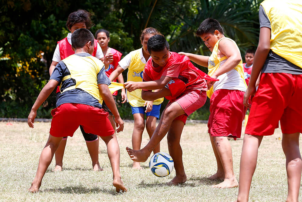 Happy young people play football in Samoa
