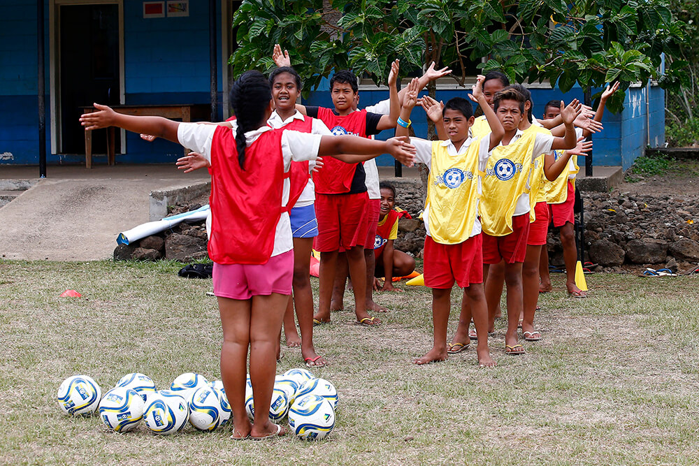 Happy young people play football in Samoa