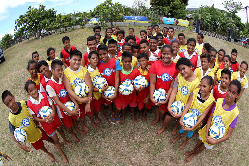 Happy young people play football in Samoa