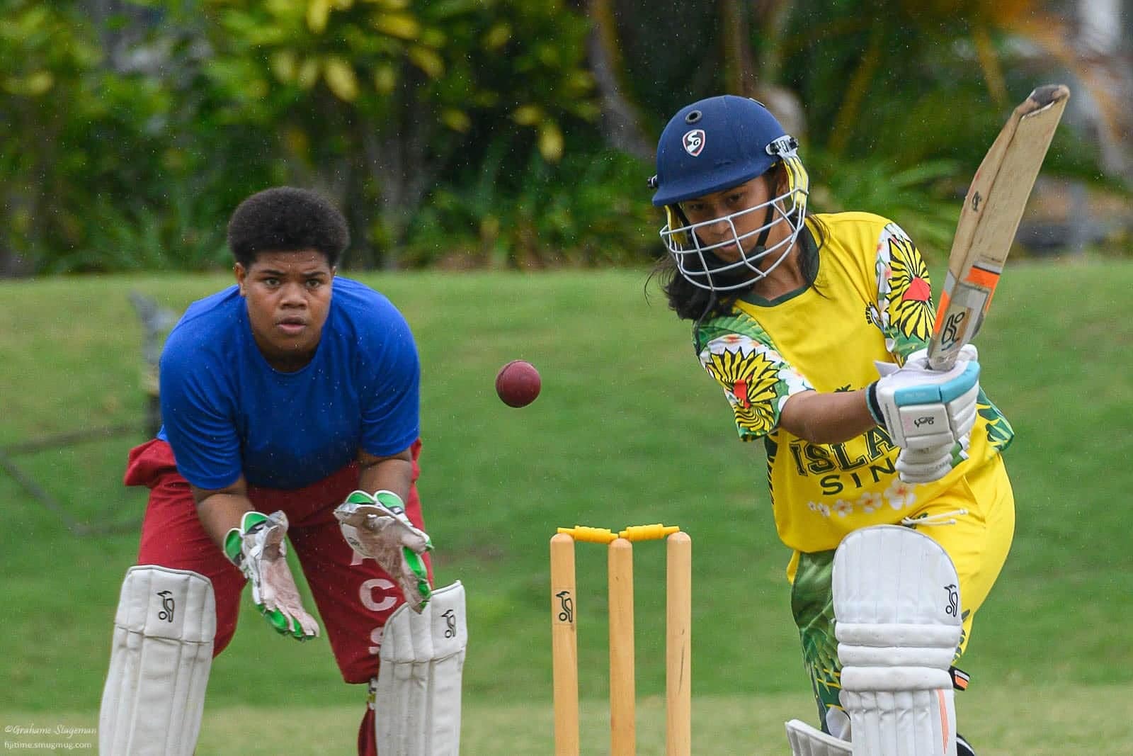 Young people play cricket in Fiji
