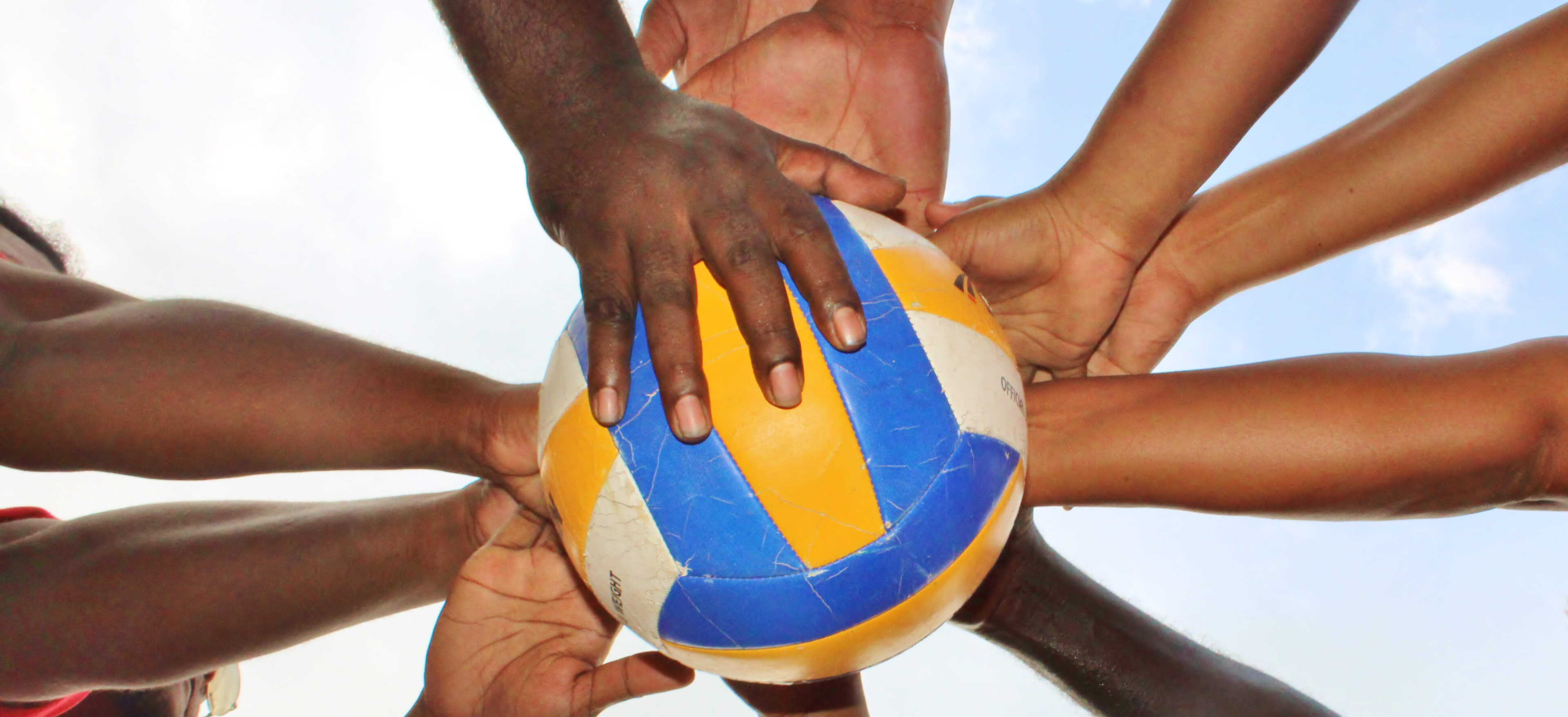 Multiple pairs of hands on a valley ball