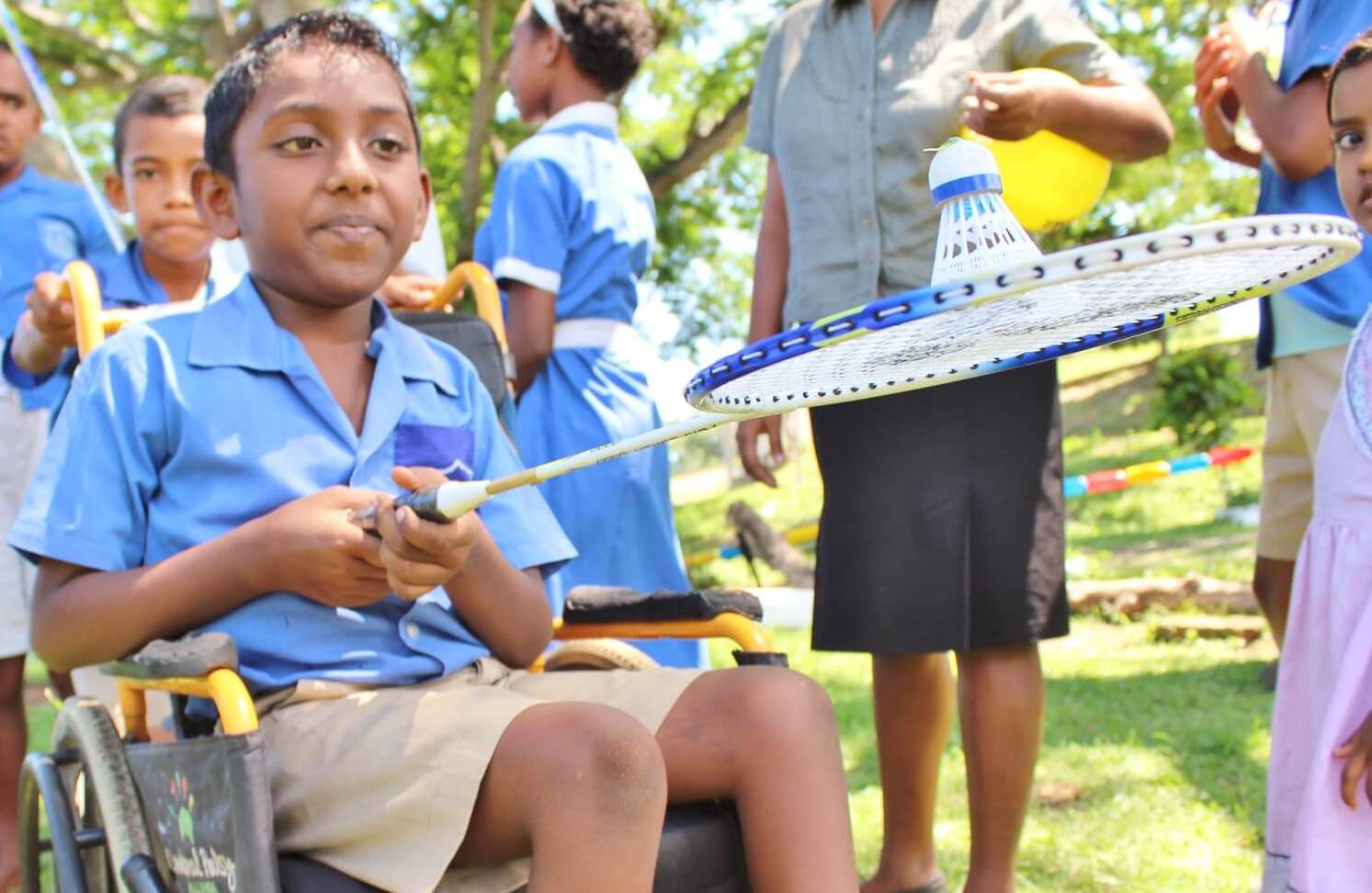 boy in wheelchair with a badminton raquet 
