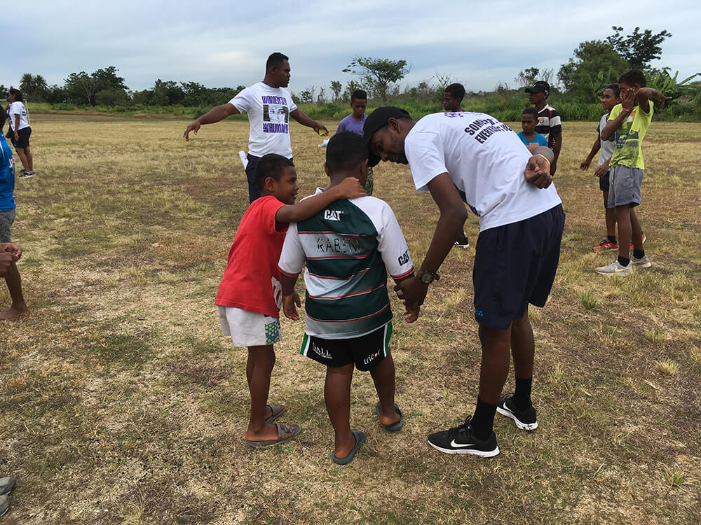 Volunteers and community members playing rugby in Fiji