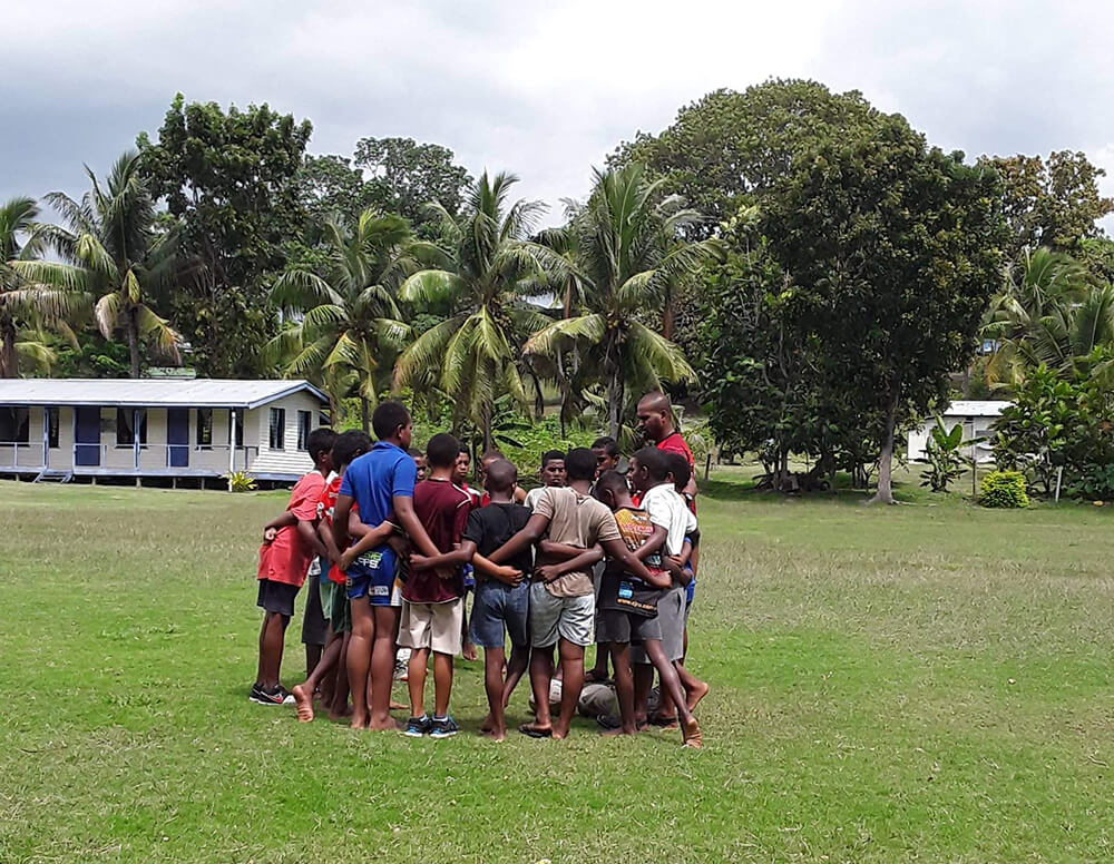 Volunteers and community members playing rugby in Fiji