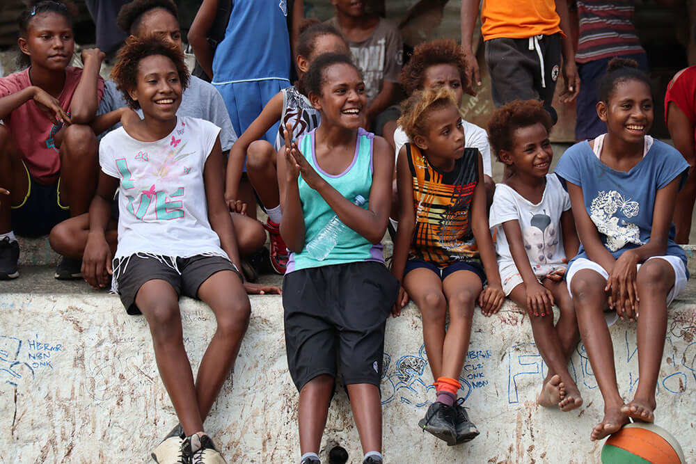 Young people watch basketball in Papua New Guinea