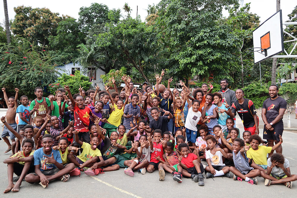 Big happy group play basketball in Papua New Guinea