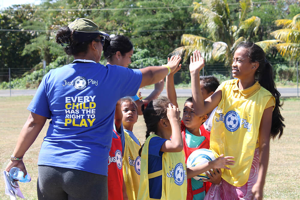 Happy young people play football in Samoa