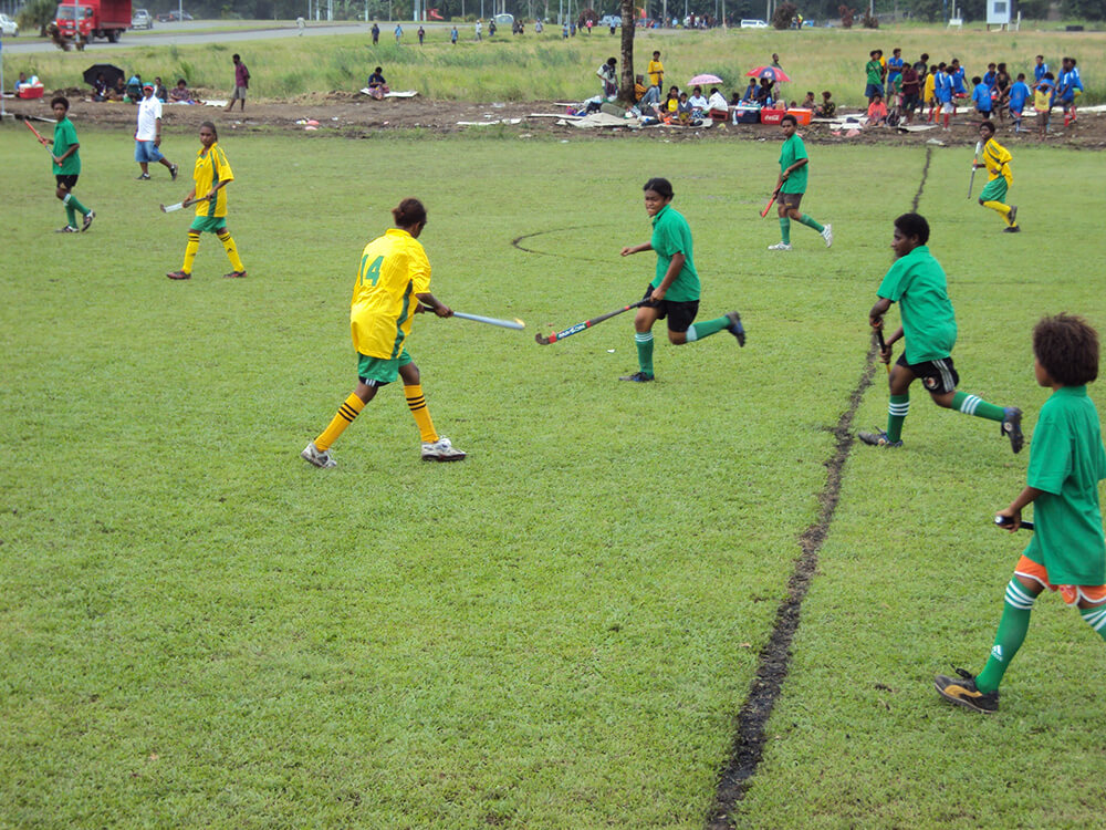 Community members playing hockey in Papua New Guinea