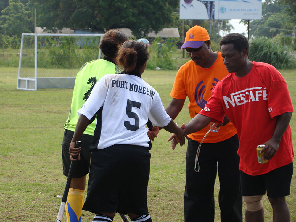 Community members playing hockey in Papua New Guinea
