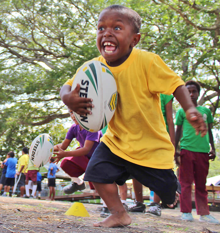 child running with rugby ball