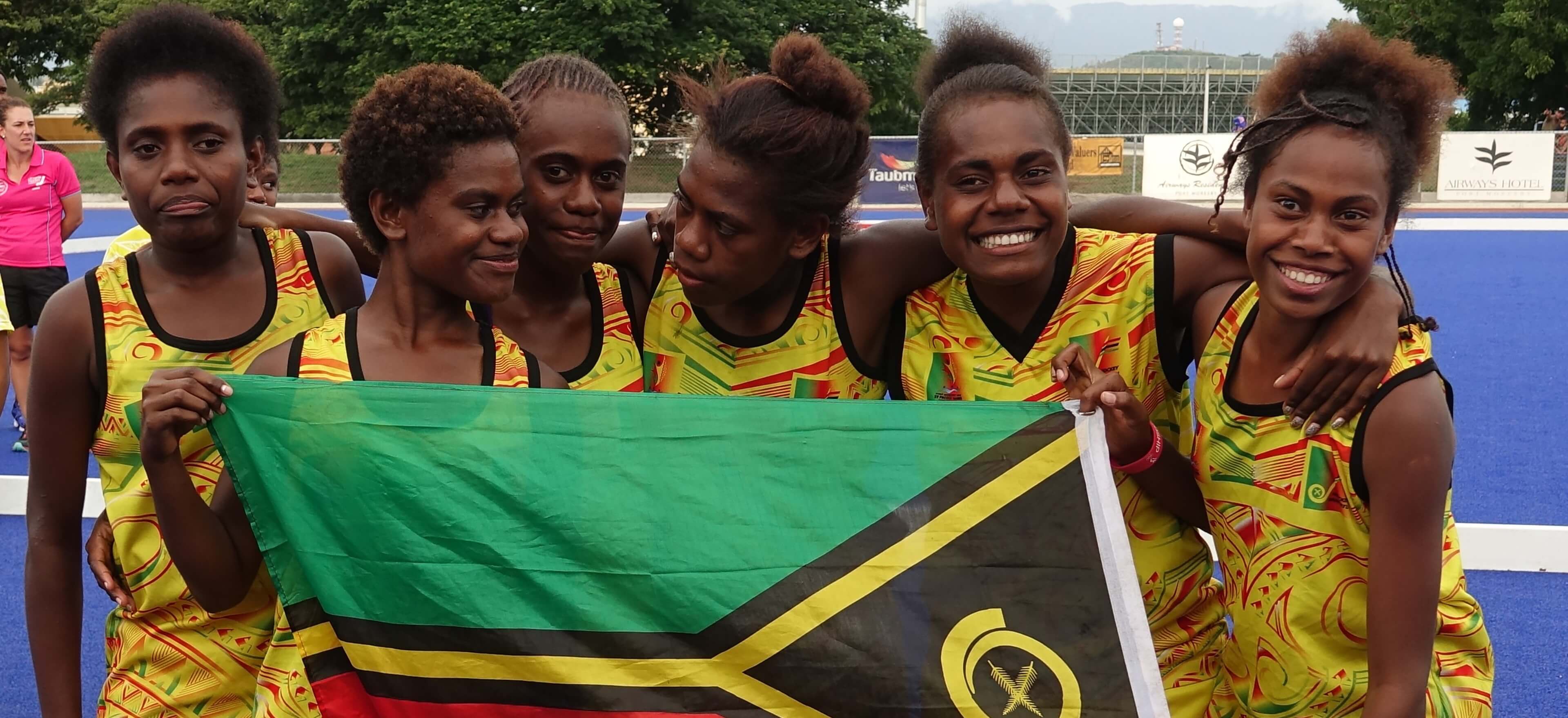 Under-18 women's hockey team celebrates with Vanuatu flag