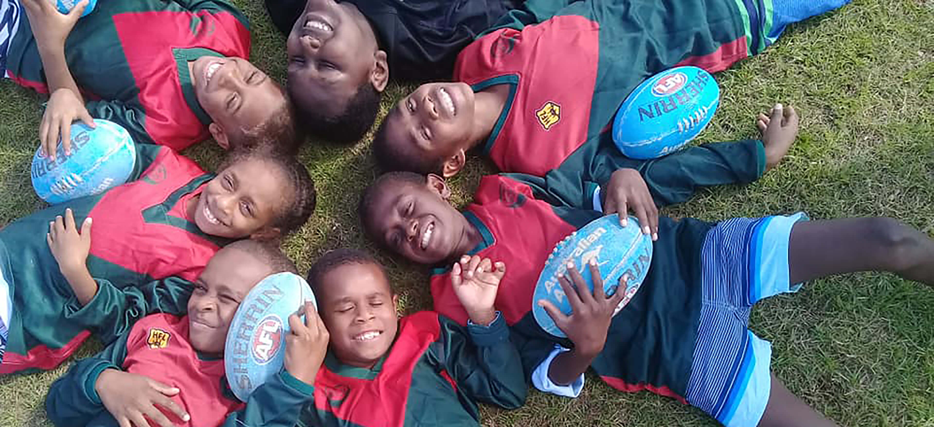 kids laying in grass in a cirlce