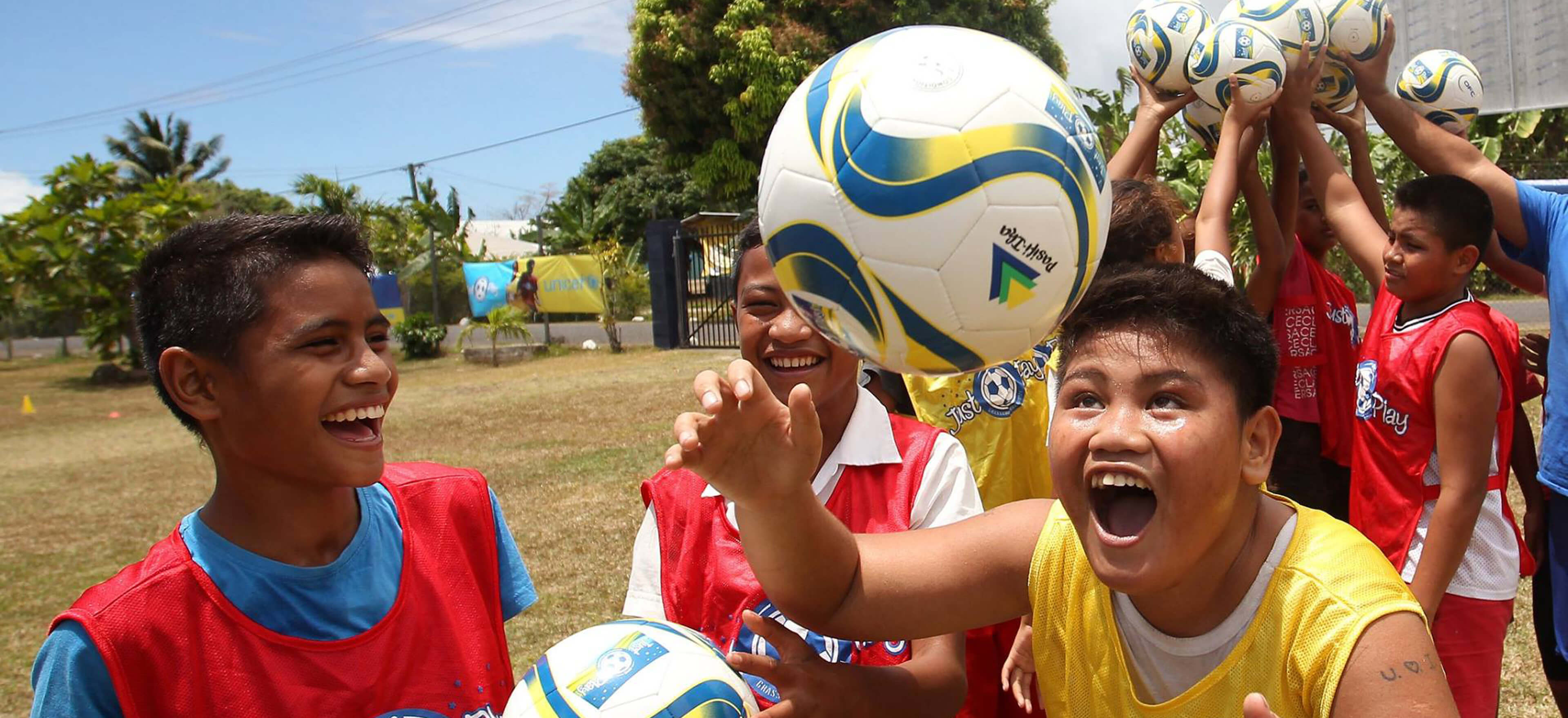 Kids reach for the football in Samoa
