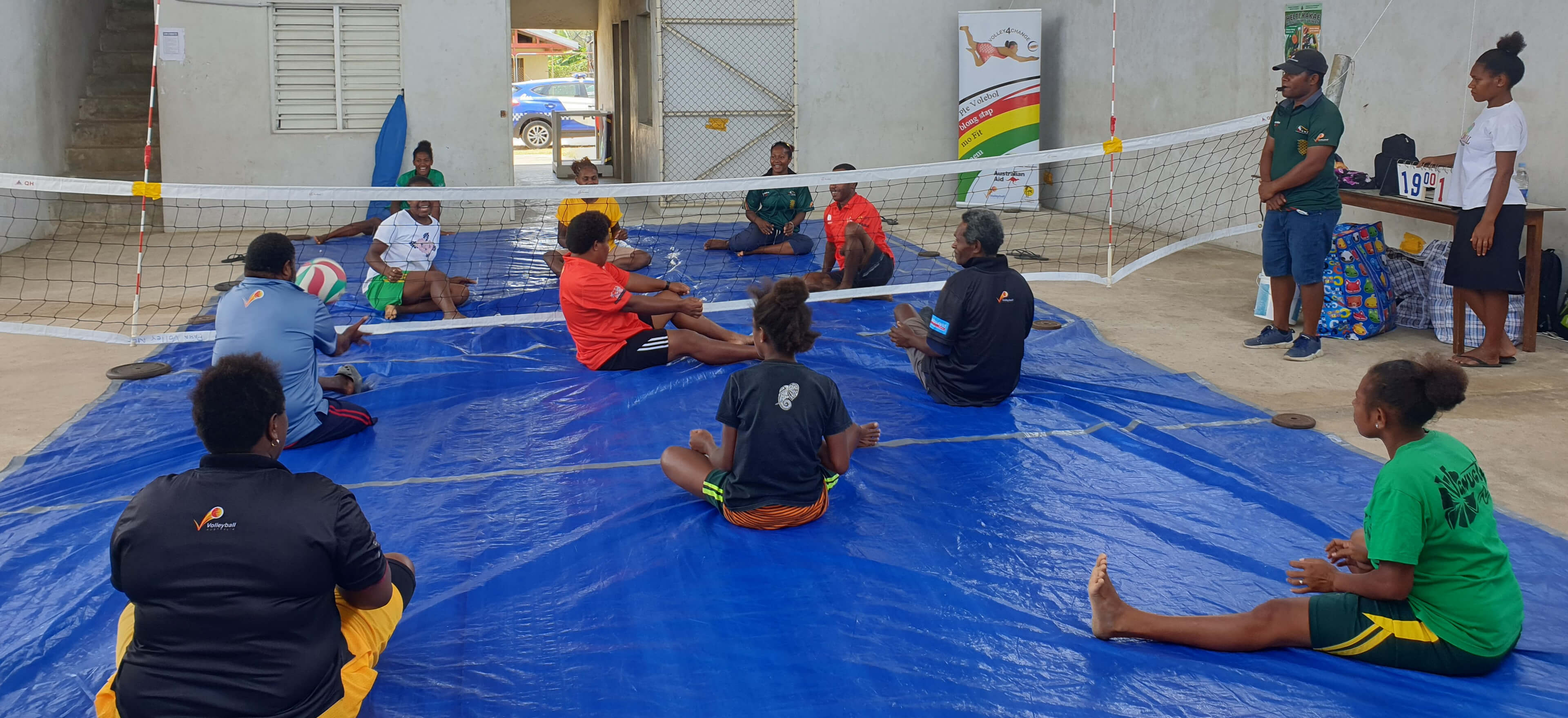 People sitting down to play volleyball in Vanuatu