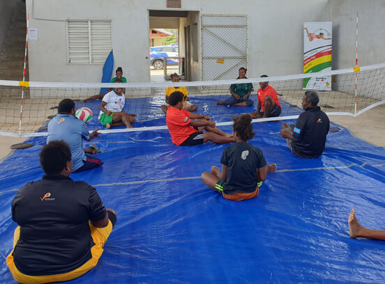 People sitting down to play volleyball in Vanuatu 