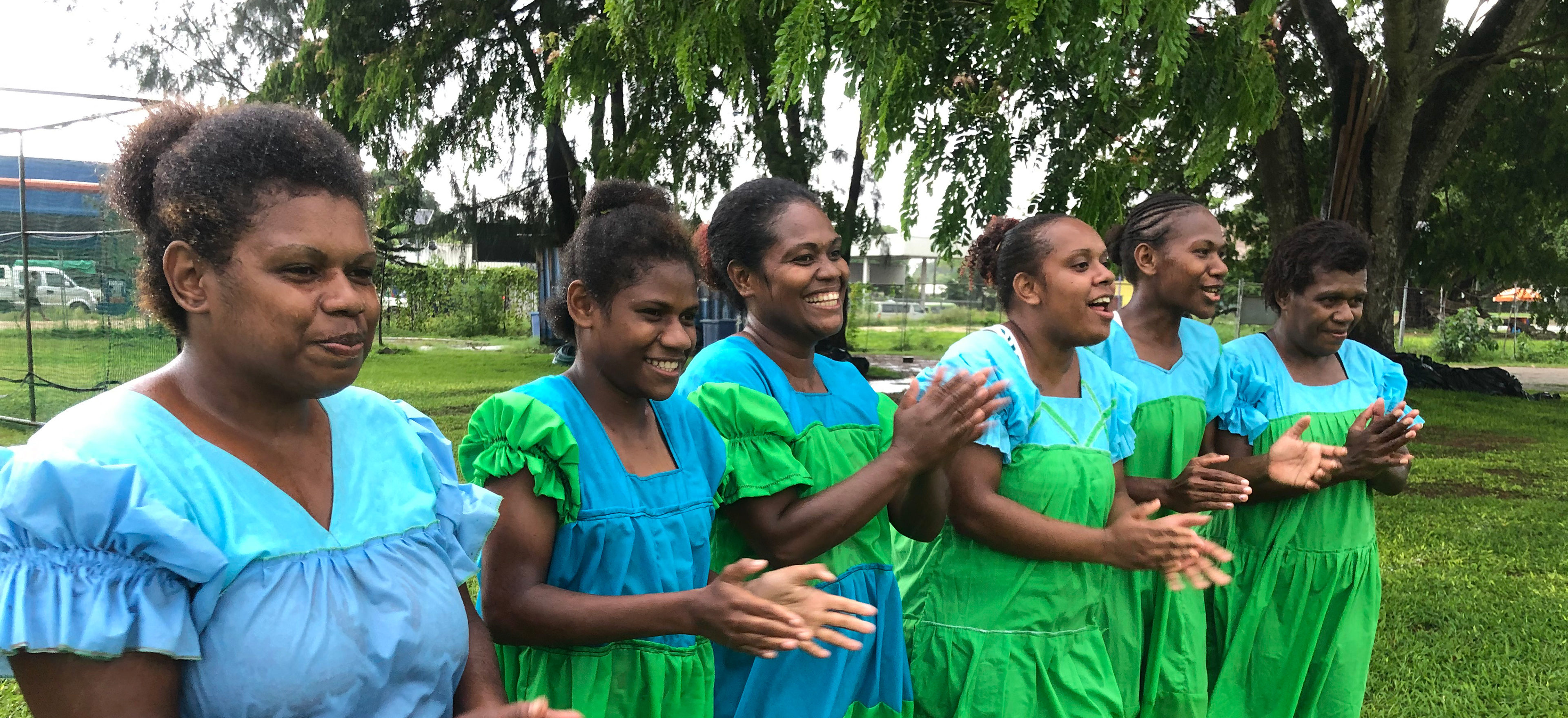 Women cheering while wearing traditional dresses in Vanuatu