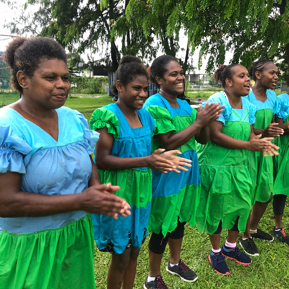 Women cheering while wearing traditional dresses in Vanuatu