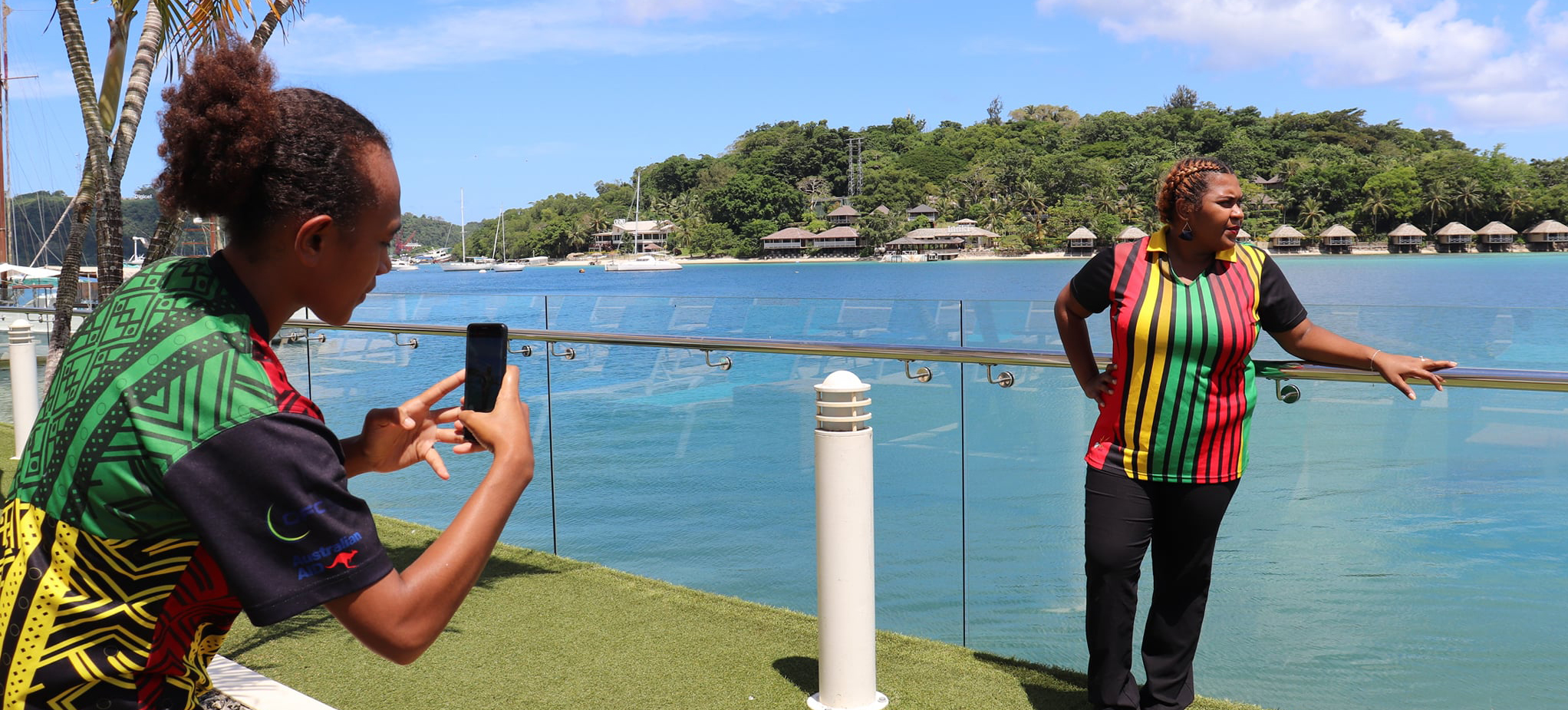 A woman in Vanuatu photographing another woman using a mobile phone