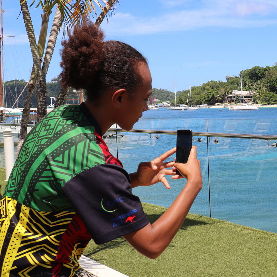 A woman in Vanuatu photographing another woman using a mobile phone
