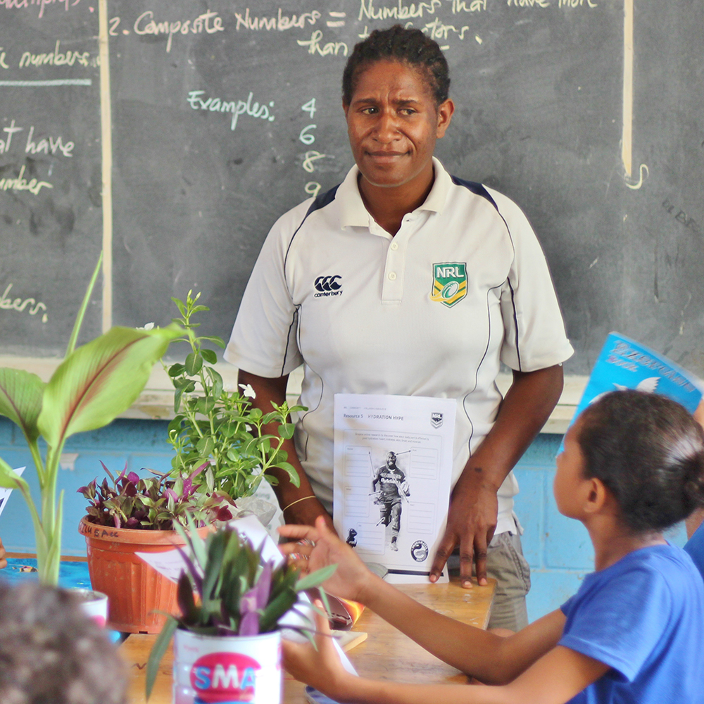 A woman in Papua New Guinea teaching a class of children