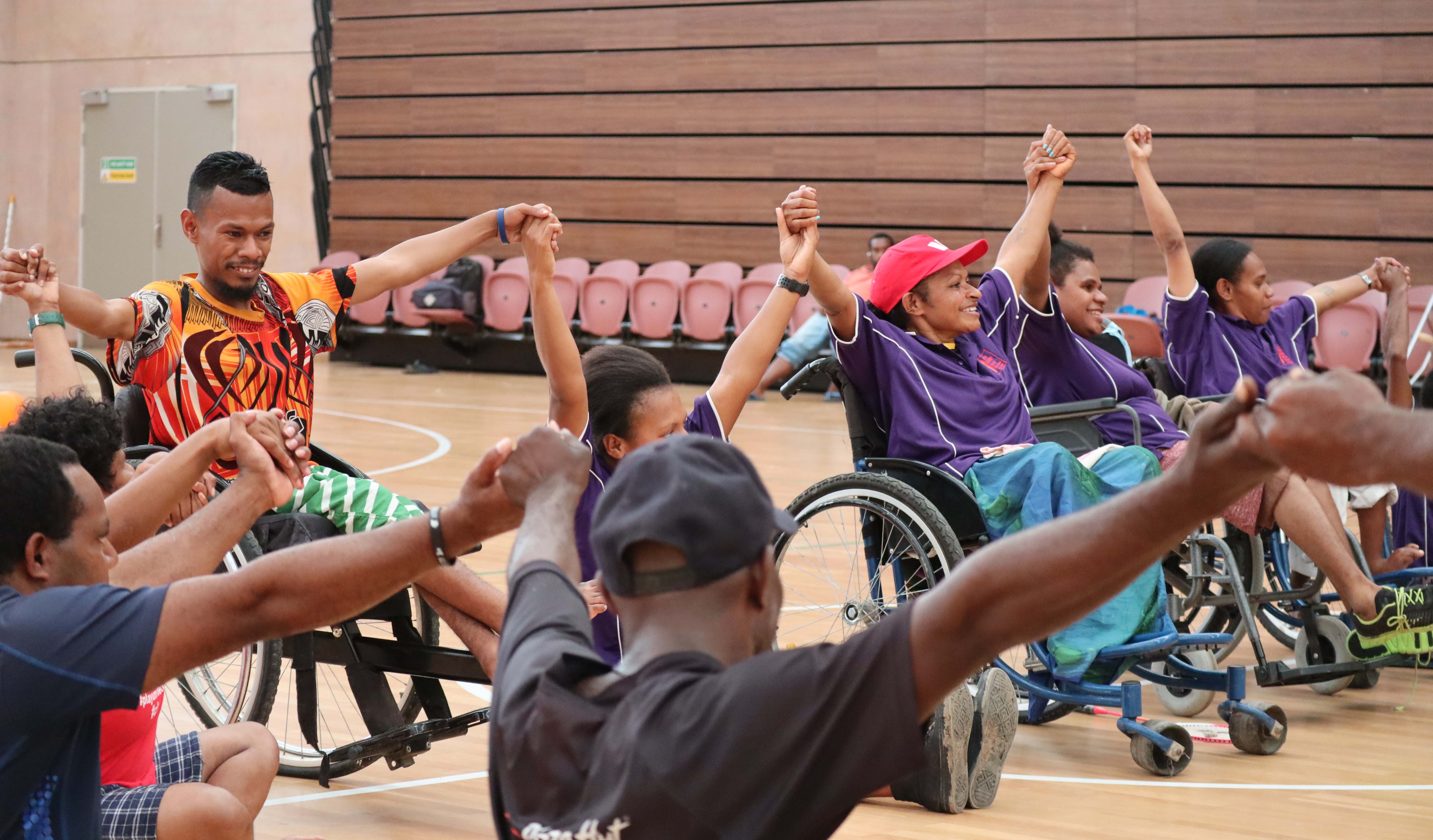 People in wheelchairs in Papua New Guinea holding hands