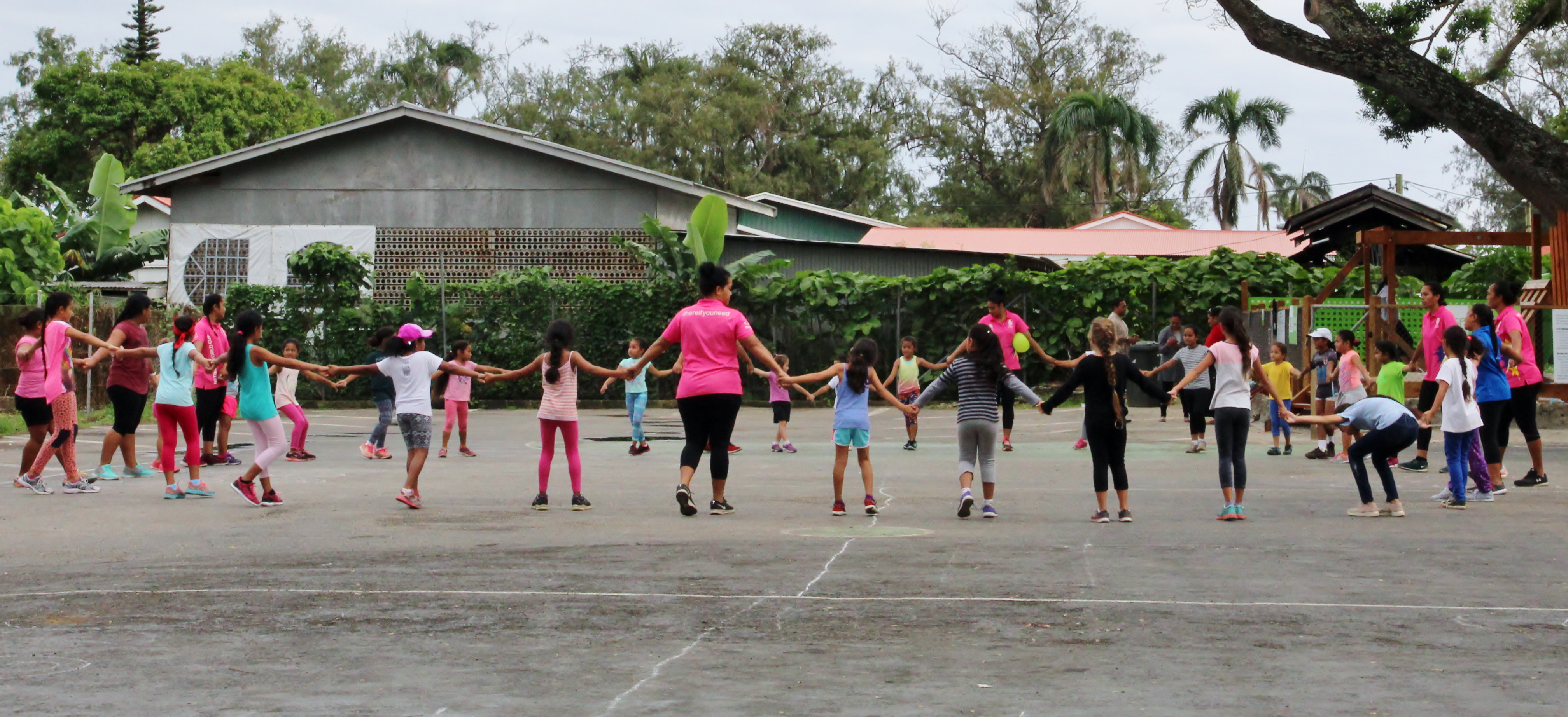 A group of girls holding hands in a school yard