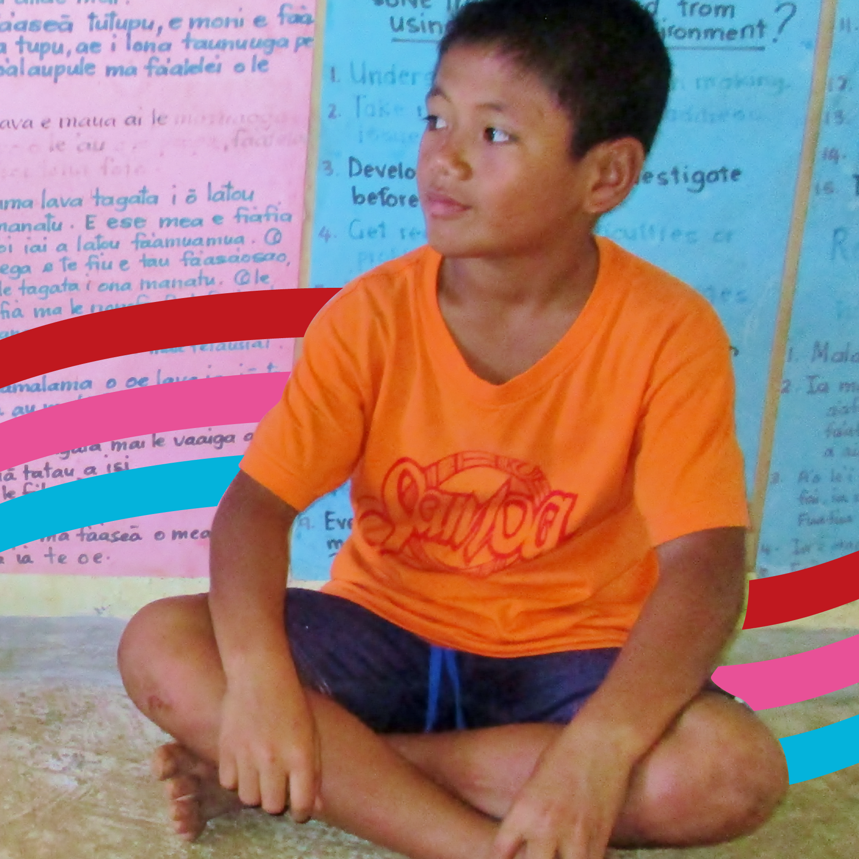 A schoolboy in Samoa sitting on the ground 