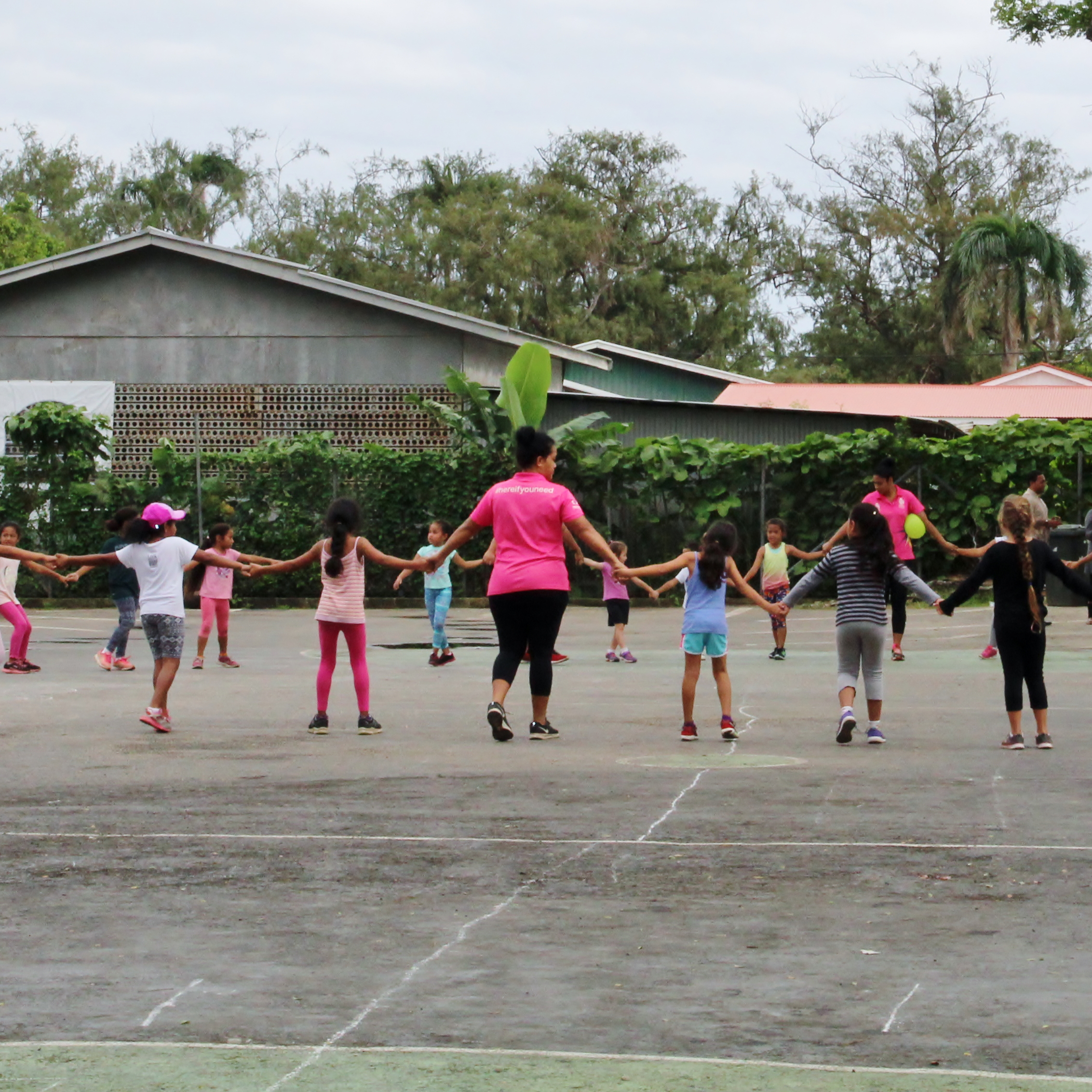 A group of girls holding hands in a school yard