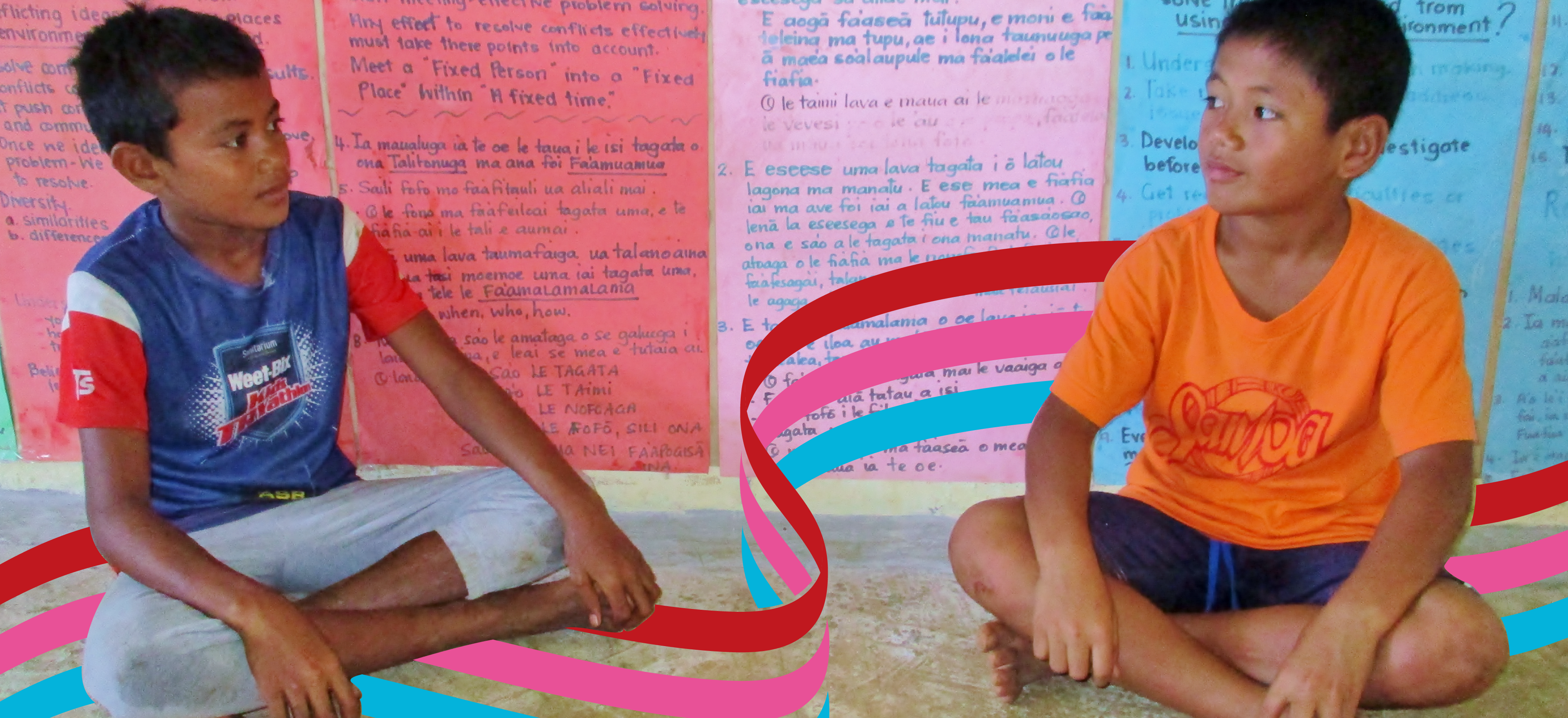 Two schoolboys in Samoa sitting on the ground