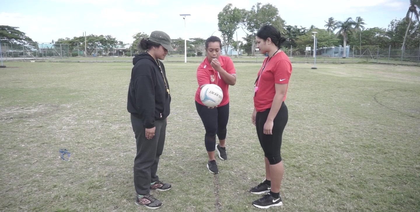 Three women in Tonga starting a netball match 