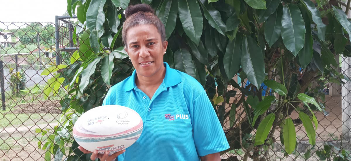 A woman in Fiji holding a rugby ball