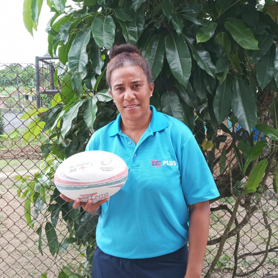 A woman in Fiji holding a rugby ball