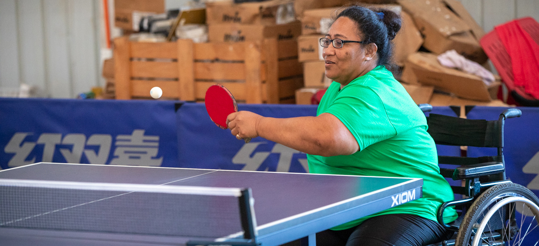 A woman in a wheelchair in Tonga playing table tennis