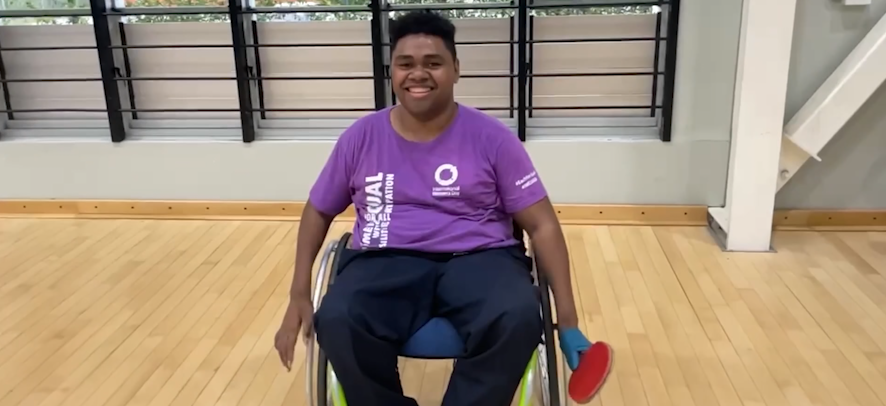 A Fijian man in a wheelchair holding a table tennis bat