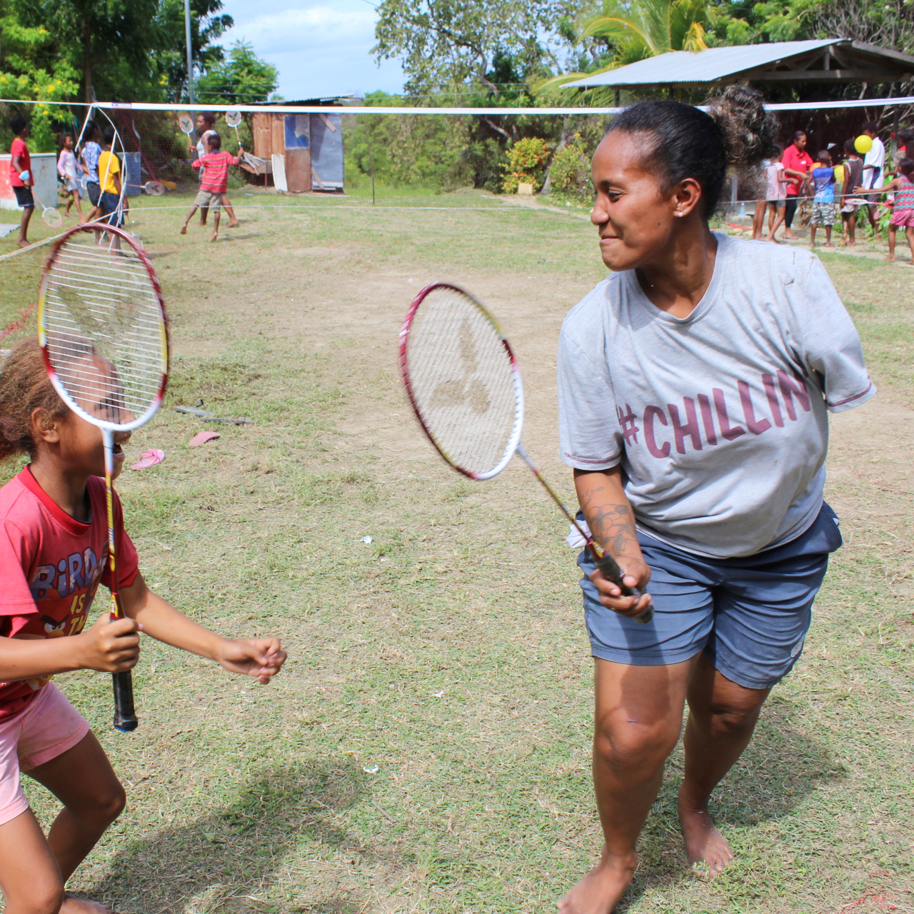 A woman and child holding badminton racquets in Papua New Guinea