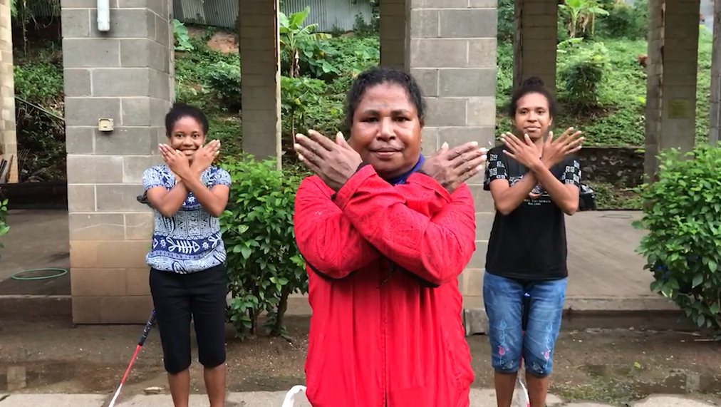 Three women standing with their arms crossed in front of them signifying the International Women's Day 2022 Break The Bias sign 