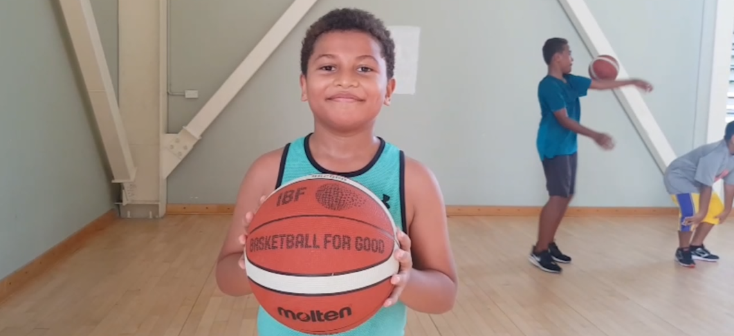 A boy in Fiji holding a basketball