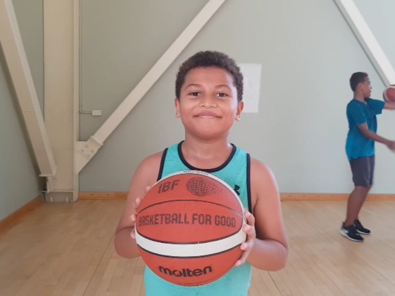 A boy in Fiji holding a basketball