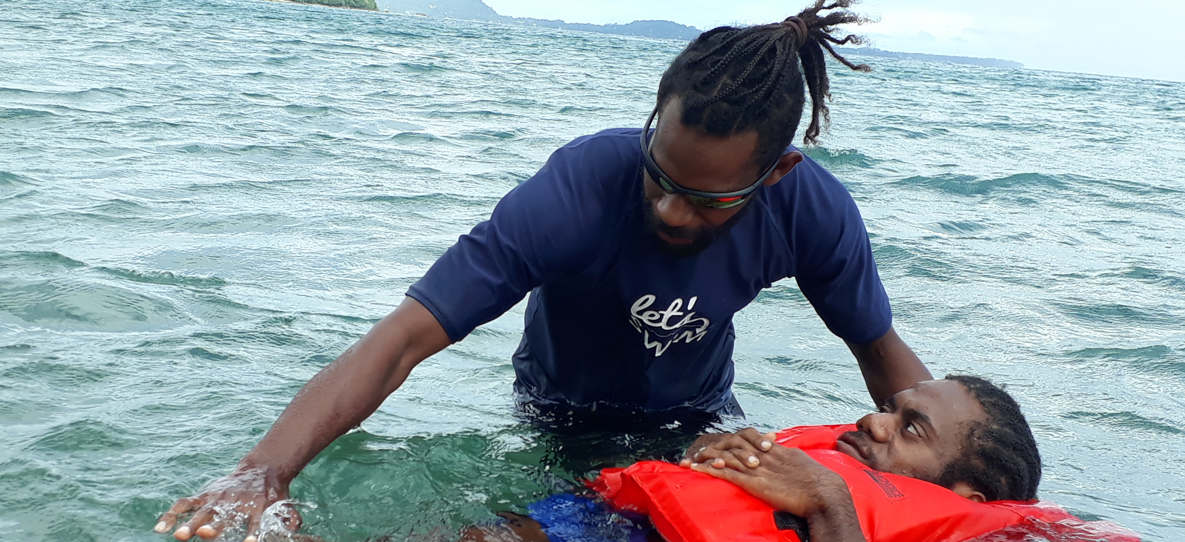 A man in Vanuatu teaching another man how to swim