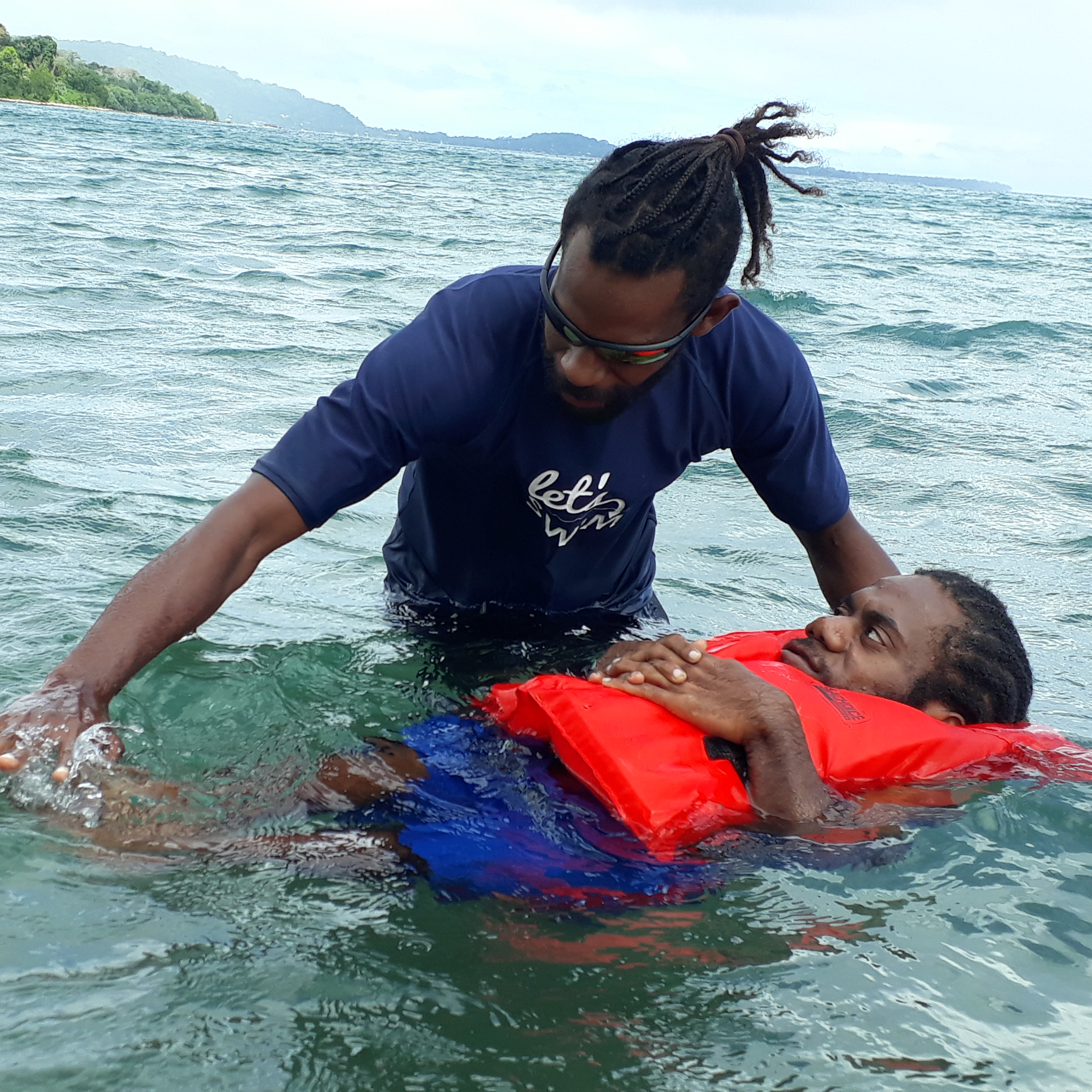 A man in Vanuatu teaching another man how to swim 