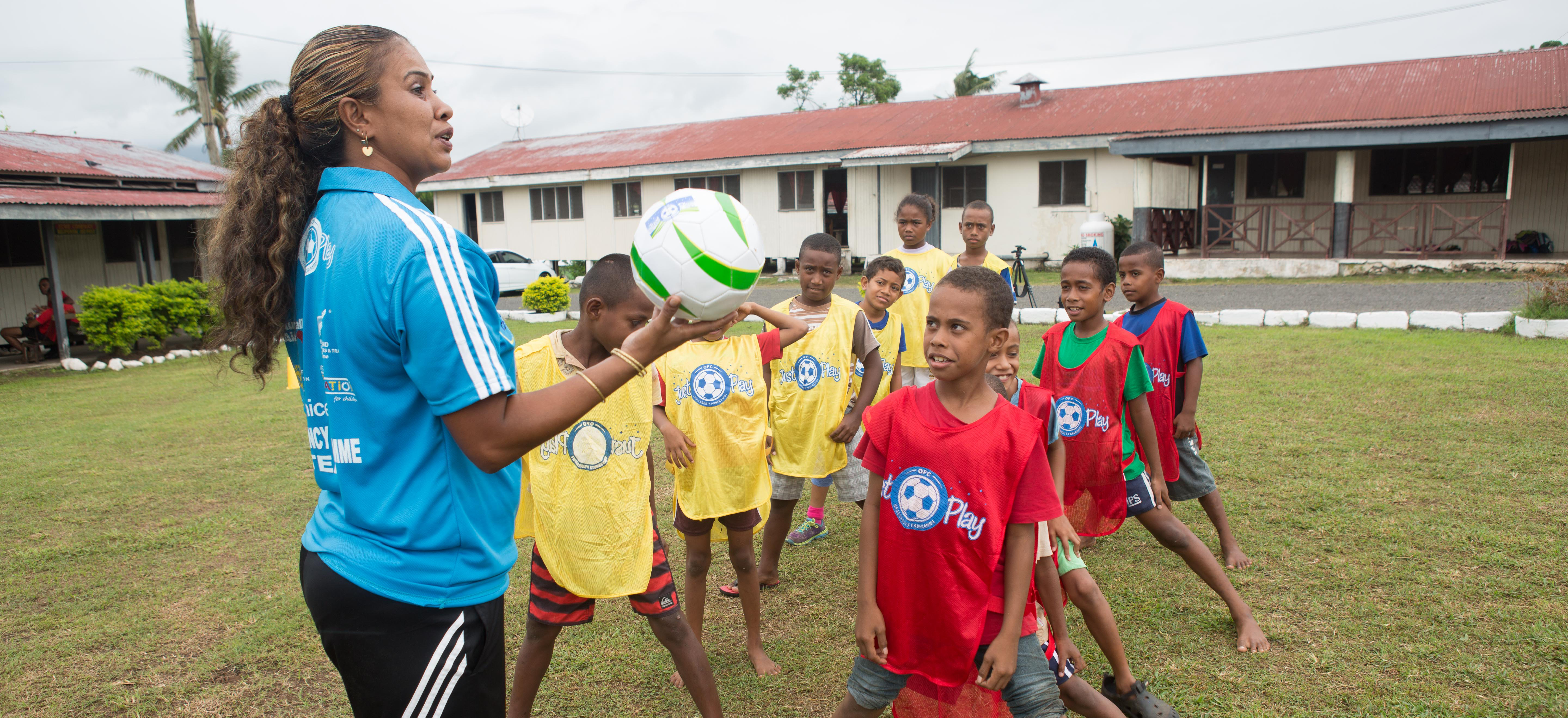 A woman running a football session for children in Fiji