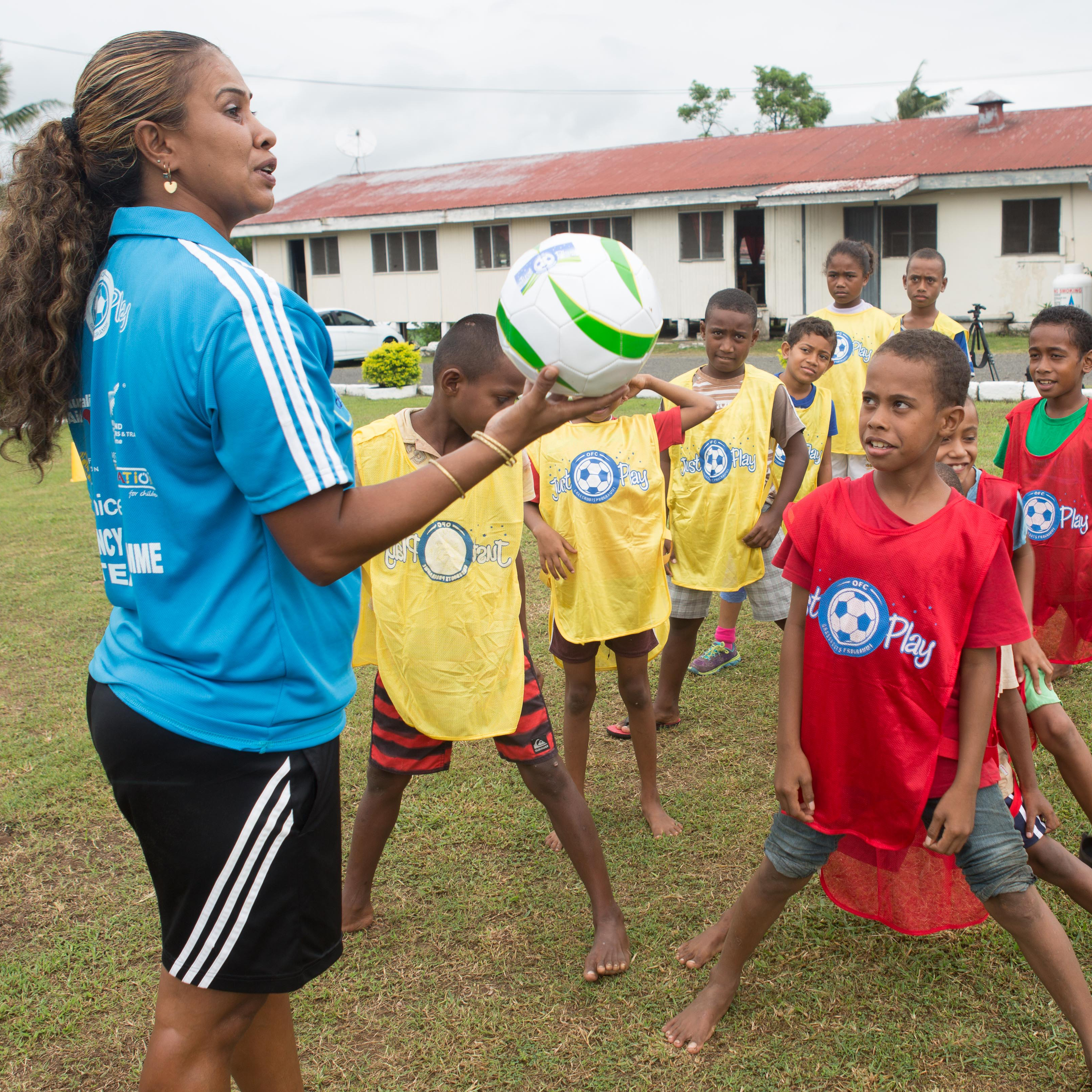 A woman running a football session for children in Fiji