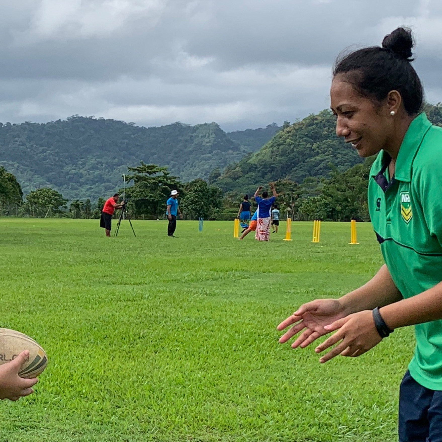 A woman in Samoa teaching rugby skills to a girl 