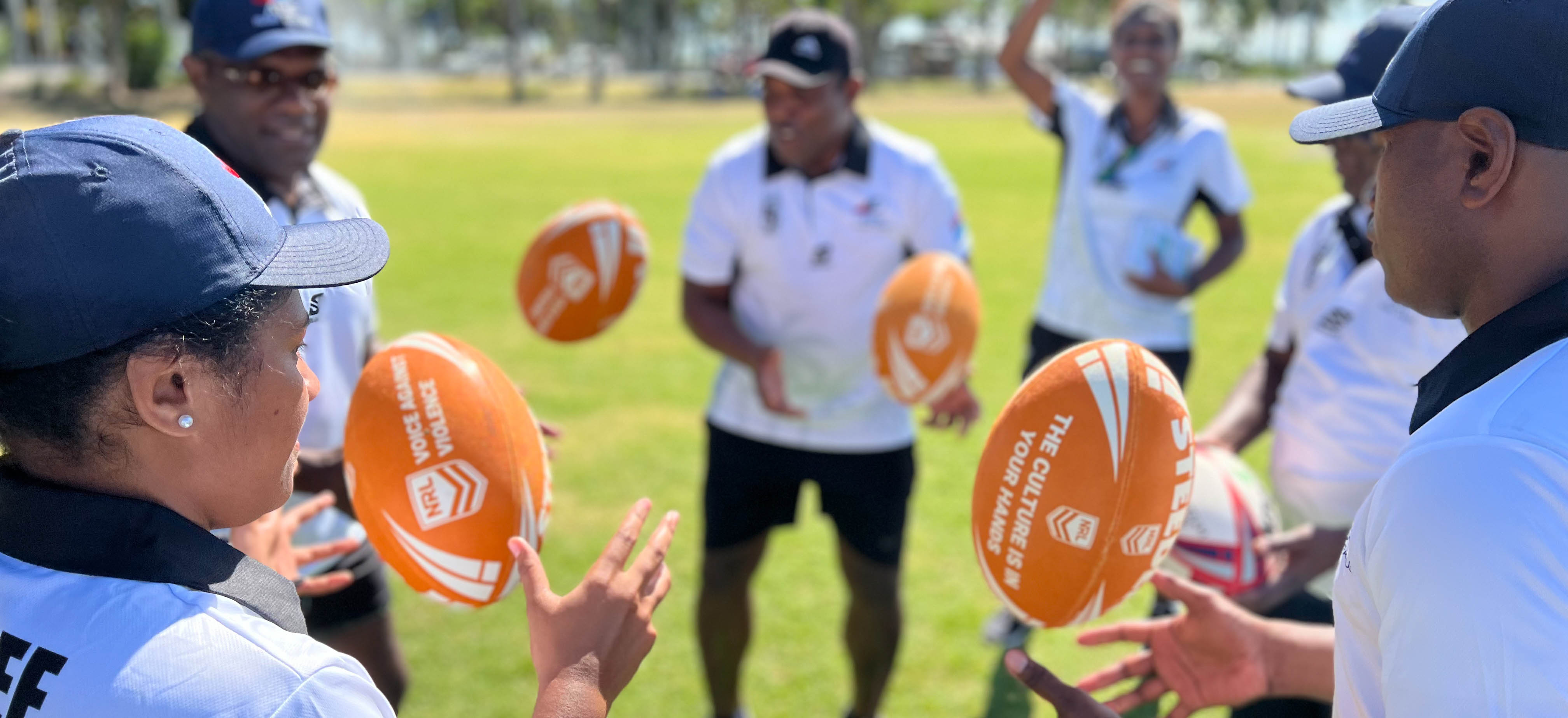 People in Fiji throwing rugby balls