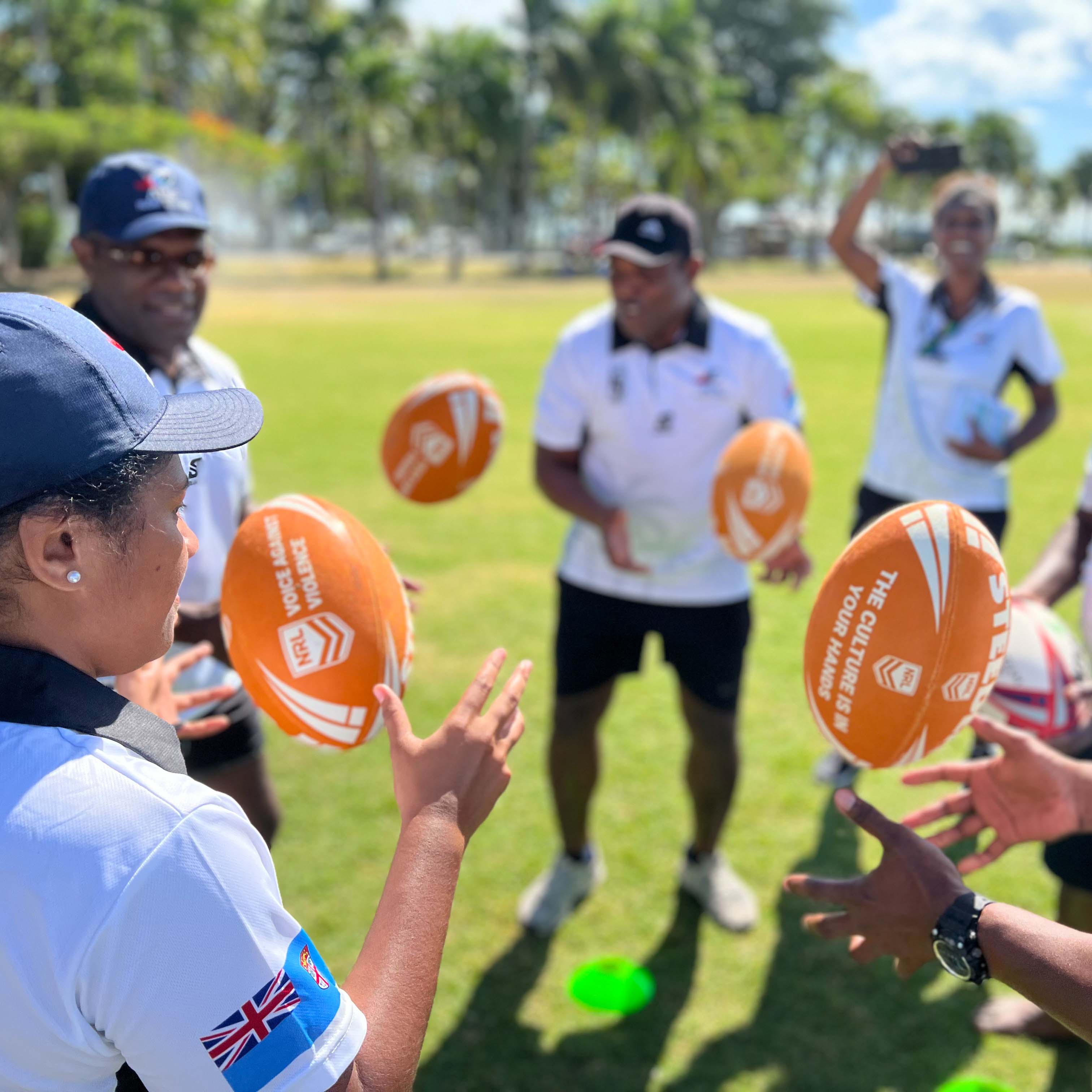 People in Fiji throwing rugby balls 