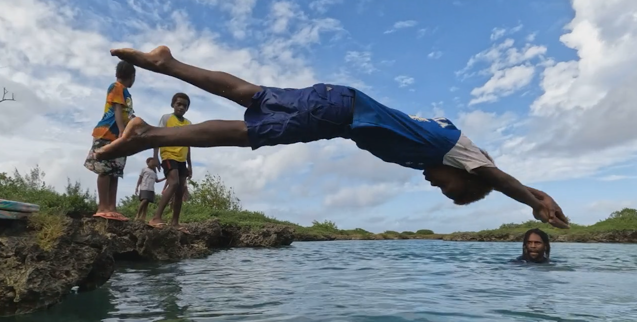 A child in Vanuatu diving into the water